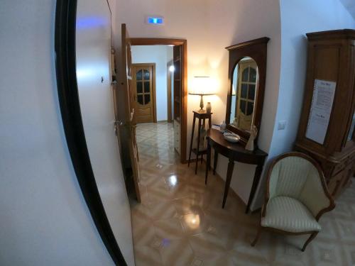 um corredor com uma mesa, uma cadeira e um espelho em Casa Rossi em Pomigliano dʼArco