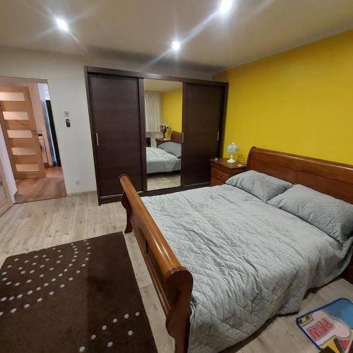 a bedroom with a bed and a yellow wall at Sunstreet in Lubin