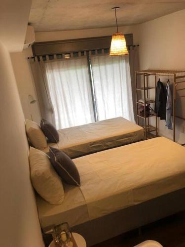 a bedroom with two beds and a window at Casi a nuevo, moderno y bien ubicado in Montevideo