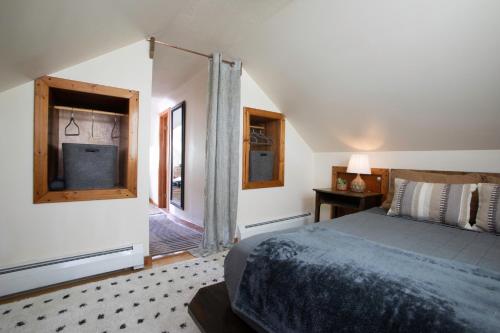 Cozy Tiny Haus Apt في Torrington: غرفة نوم بسرير وباب زجاجي منزلق