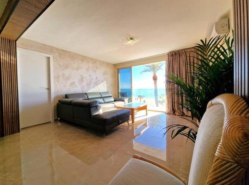 リョレート・デ・マルにあるLloret Paradise Apartmentsのリビングルーム(ソファ付)が備わり、海の景色を望めます。