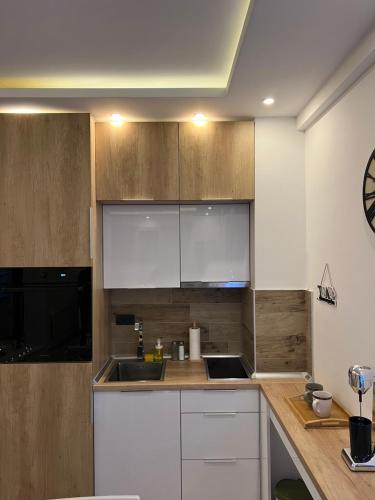 a kitchen with white cabinets and a sink at Milmari N lux Sena in Kopaonik