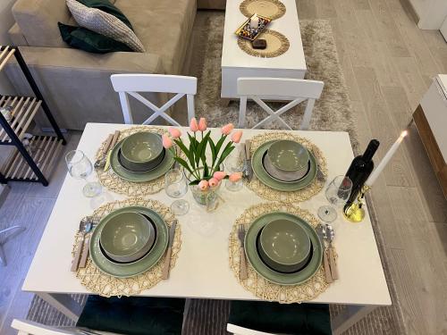 a table with green plates and flowers on it at Milmari N lux Sena in Kopaonik