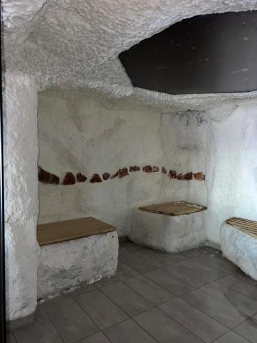 a room with two benches in a white wall at Milmari N lux Sena in Kopaonik