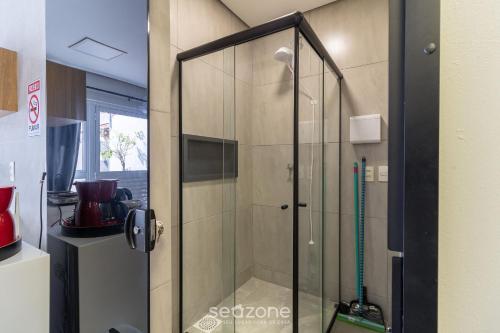 y baño con ducha y puerta de cristal. en Studio moderno em Sta. Mônica ASK002, en Florianópolis