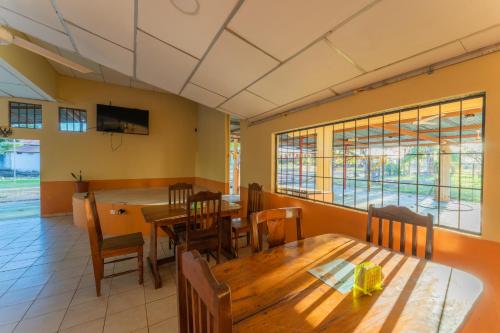 a dining room with wooden tables and chairs at Hotel El Cocobolo Food&Rest Room 1 B&B WiFi AC Pkg Free Swimmingpool in Ahogados