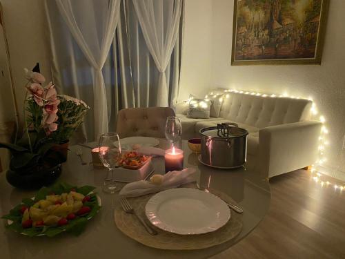 a dining room table with a candle and plates and a candle at Conforto na Praia do Pontal in Rio de Janeiro