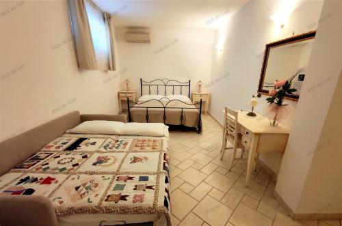 オストゥーニにあるBed & Breakfast dei Colliのベッドルーム1室(ベッド2台、デスク、鏡付)