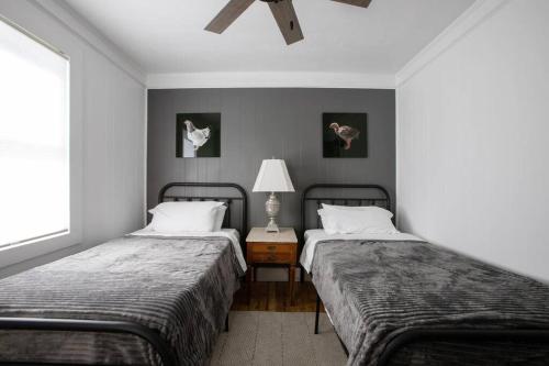 a bedroom with two beds and a table with a lamp at Cozy Modern Farmhouse 2 Bedroom Apartment in Torrington