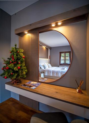 a bedroom with a christmas tree and a mirror at Erofili Hotel & Suites in Portaria