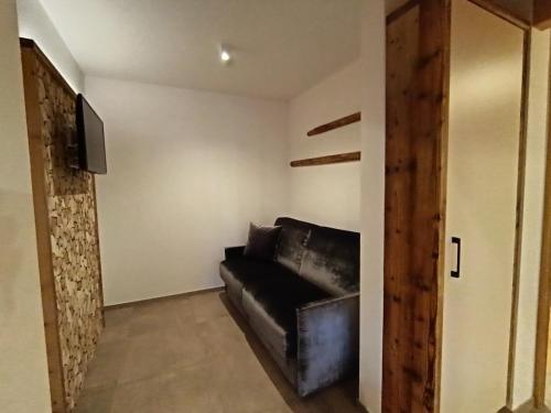 uma sala de estar com um sofá de couro e uma televisão de ecrã plano em Apartment 4 em Prato alla Drava