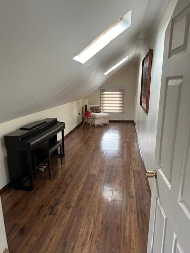 a living room with a piano and a room with a door at Acogedora Casa con Tinaja y Jacuzzi y RENT A CAR in Puerto Varas