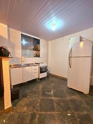 een keuken met een witte koelkast en een aanrecht bij Casa / kitinete in Juiz de Fora