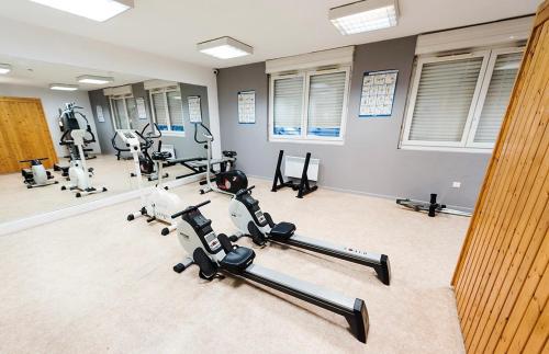 einen Fitnessraum mit mehreren Heimtrainern und Laufbändern in der Unterkunft Superbe Studio de 23m² in Nîmes