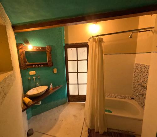 a bathroom with a shower and a sink and a tub at Casa La Molina in Tilcara