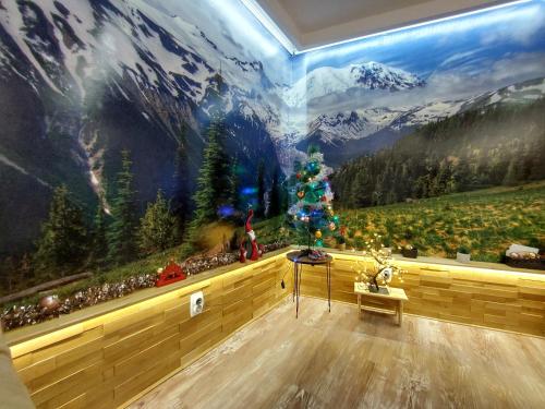 パレにあるStan SKのクリスマスの木と山の壁のある部屋