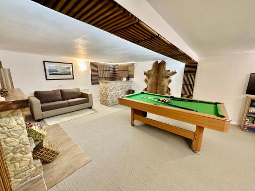 a living room with a pool table and a couch at Chalet Charlotte in Fusch an der Glocknerstraße