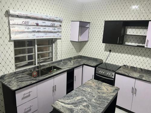 a kitchen with white cabinets and a sink and a counter at Muniz Apartments in Lagos