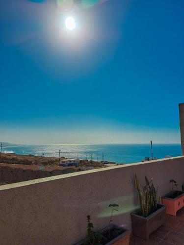 uma vista para a praia a partir de uma varanda de um edifício em taghazout life Guest House em Taghazout