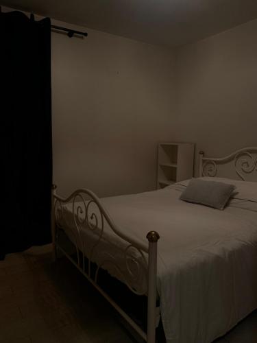 a bedroom with a white bed with a white blanket at Domaine de Nina in Houdan
