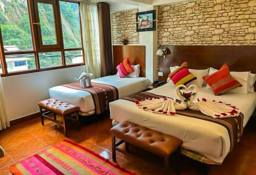 a hotel room with two beds in a room at Hotel Machupicchu Adventure in Machu Picchu