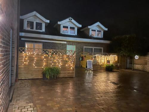 a house with a fence with christmas lights on it at Hallo Maastricht B&B Fientje de luxe in Maastricht