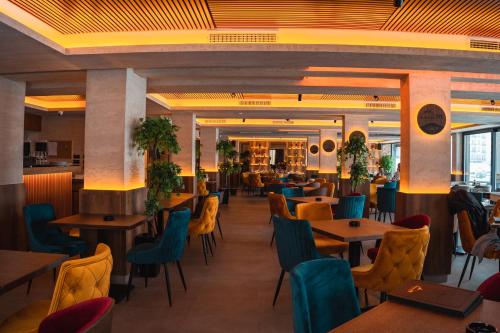 un restaurante con mesas y sillas de madera y una cafetería en Milmari Apartments FREE SPA & PARKING Kopaonik, en Kopaonik