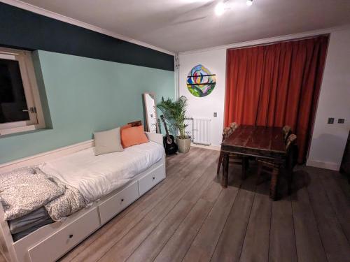 OudeschootにあるTuinkamer Oudeschootの大きなベッドとテーブルのある寝室