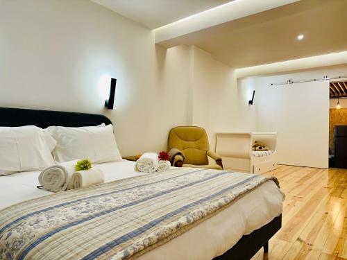 a bedroom with a large bed and a chair at A casa na Estrela in Lisbon