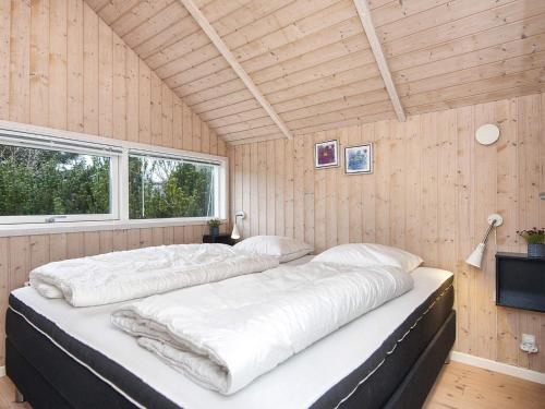 a bedroom with two beds in a room with wooden walls at Holiday home Ebeltoft CXXXVI in Ebeltoft