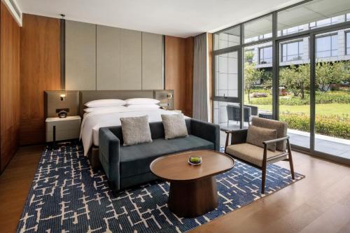 a hotel room with a bed and a couch and a table at Sheraton Xuzhou in Xuzhou