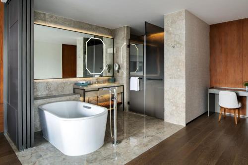 a bathroom with a tub and a sink at Sheraton Xuzhou in Xuzhou