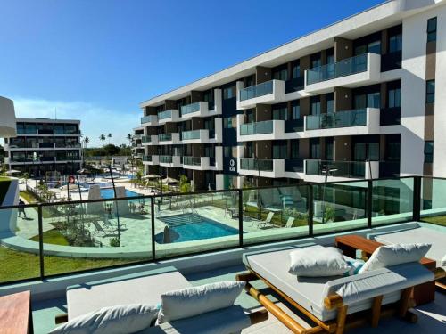 un edificio de apartamentos con balcón y piscina en Makia Beach Experience - Flat 16A - TÉRREO - SOFT OPENING, en Porto de Galinhas