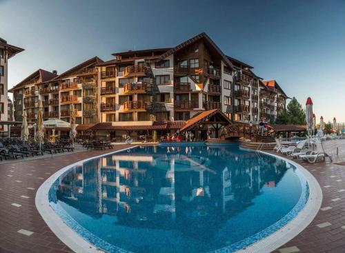 a large swimming pool in front of a hotel at VIP Apartment Belvedere Club in Bansko