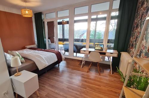 a bedroom with a bed and a desk and a table at Archipel Homes neu & gemütlich, zentral, nähe Hamburg und Lüneburg in Geesthacht