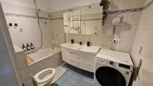 a white bathroom with a toilet and a sink at ARCHIPEL - Balkon - nahe Hamburg - BBQ Grill - Smart TV - 2,5 Bäder - Lounge in Geesthacht