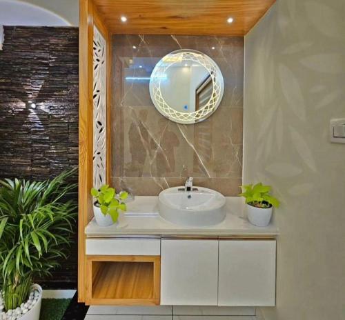 ein Bad mit einem Waschbecken und einem Spiegel in der Unterkunft FIRSTHOUSE VILLA@BATU FERRINGHI in Batu Feringgi