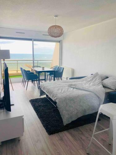 une chambre avec un lit, une table et des chaises dans l'établissement 029- Appart 1 chambre, vue sur Mer, 1ère ligne *, à Mauguio