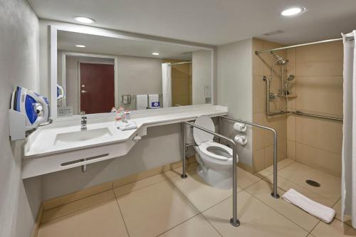 ein Badezimmer mit einem Waschbecken, einem WC und einem Spiegel in der Unterkunft City Express by Marriott Ciudad Obregon in Ciudad Obregón