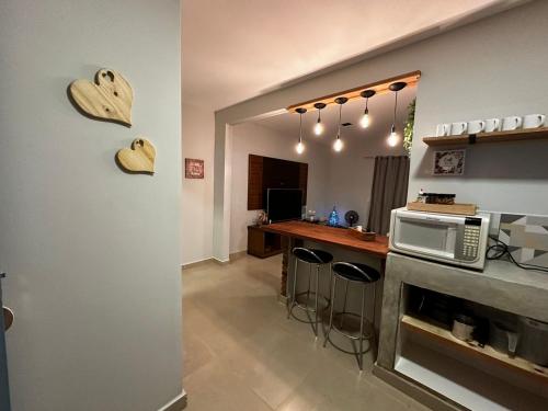 a kitchen with a counter with a microwave and hearts on the wall at Rancho Ameixeira in Paty do Alferes