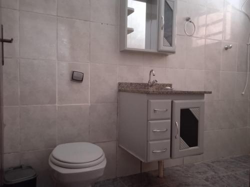 uma casa de banho com um WC, um lavatório e um espelho. em Chácara do vô Meireles em Serra Negra