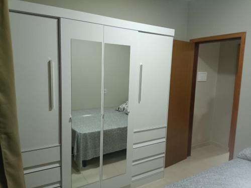 1 dormitorio con armario blanco y cama en Sobrado familiar, en São Francisco do Sul