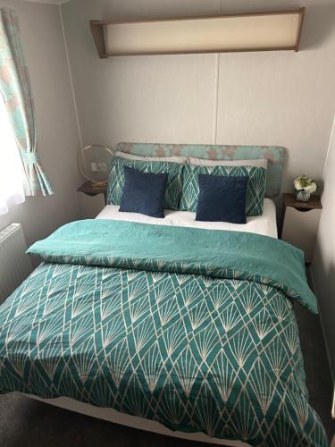 a bedroom with a bed with blue and green sheets at Seton Sands Muirfield 6 in Port Seton