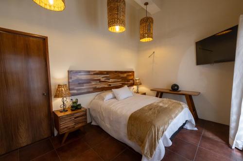 a bedroom with a bed and two lamps and two lights at CASA FORTALEZA in Oaxaca City