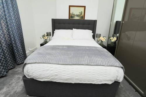 a bedroom with a large bed with white sheets at Impeccable 3 bedroom house in Plumstead