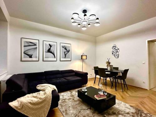 uma sala de estar com um sofá preto e uma mesa em NEW!l! Exclusive Near Opera em Viena