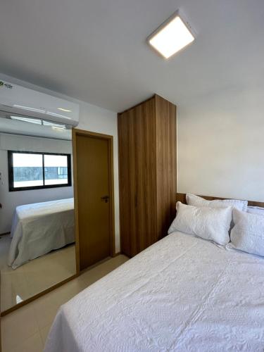 een slaapkamer met een groot bed en een spiegel bij Apartamento 1/4 in Salvador
