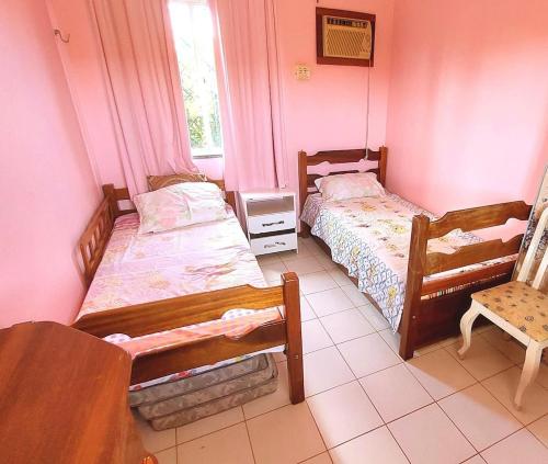 Un dormitorio con dos camas y una silla. en Condominio Sol Poente, en Salinópolis