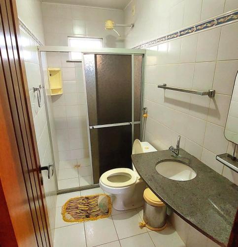 a bathroom with a shower and a toilet and a sink at Condominio Sol Poente in Salinópolis