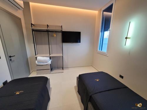 a bedroom with two beds and a tv in it at Infinity Villa in Rrushkull